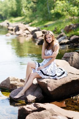 oung, nehir kıyısında elbiseli seksi kız kayalar
