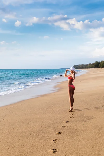 La jeune femme en bikini avec un chapeau sur une plage de sable — Photo