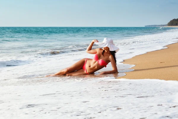 La jeune femme en bikini avec un chapeau sur une plage de sable — Photo