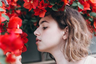 Kırmızı çiçekli genç kız. Parfüm ve organik kozmetik