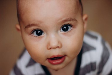 Cutte baby boy with big dark eyes and long lashes. Portrait of sweet infant