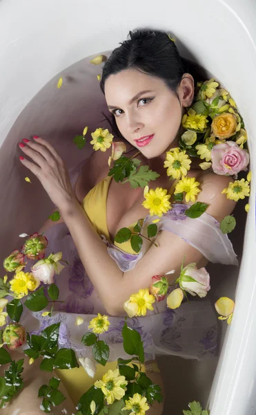 Брюне девушка в ванной с цветами — стоковое фото