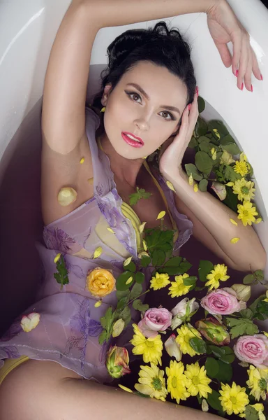 Brunette fille dans le bain avec des fleurs — Photo