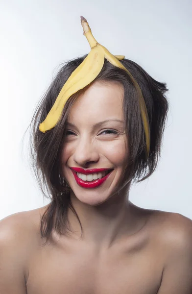 Girl with a skin of a banana on his head — Stock Photo, Image