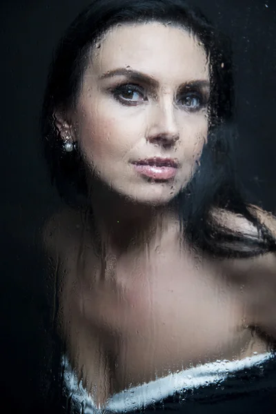 Young woman melancholy and sad at the window in the rain — Stock Photo, Image