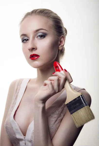 Young woman with a makeup brush building — Stock Photo, Image