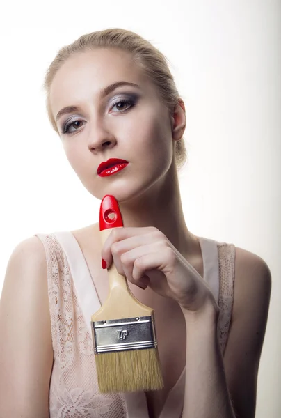 Mujer joven con un edificio de cepillo de maquillaje — Foto de Stock