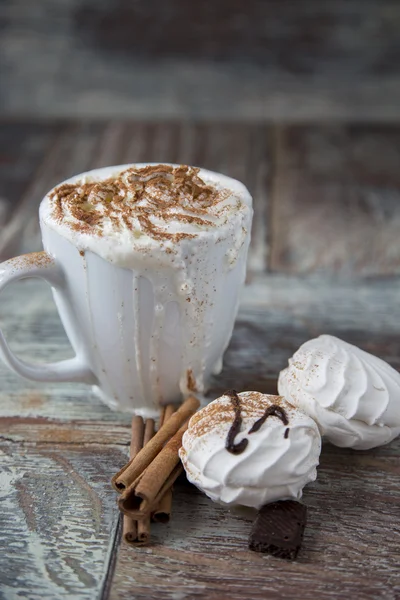 Café quente com marshmallows em uma xícara no fundo de madeira — Fotografia de Stock