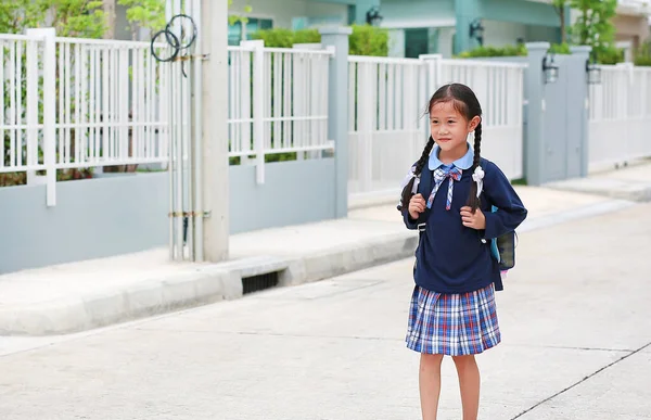幸せなアジアの小さな子供の女の子の肖像画で学校制服歩いて家を出るに学校に行くには午前中 — ストック写真