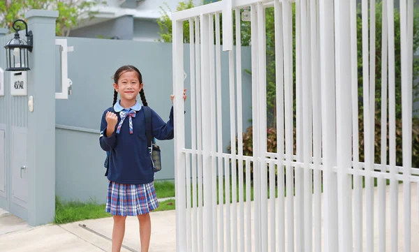 身着幼儿园校服的自信的亚洲小女孩在早上离家去学校之前 举手表决 — 图库照片