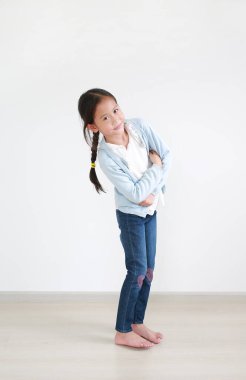 Kendinden emin ve zeki Asyalı küçük kız kameraya bakarak mutlu ve gülümseyen kollarını kavuşturdu.