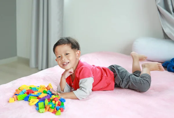 Uroczy Azjatycki Mały Chłopiec Gra Kolorowe Plastikowe Klocki Leży Łóżku — Zdjęcie stockowe