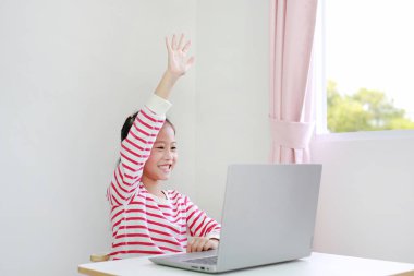 Asyalı küçük kız, evde yeni normal Covid-19 Coronavirüs sırasında öğretmenle bilgisayardan bilgisayar üzerinden video öğrenme dersi alıyor..