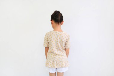 Beyaz arka planda saçı topuz gibi olan Asyalı küçük kızın arka planı izole edilmiş..