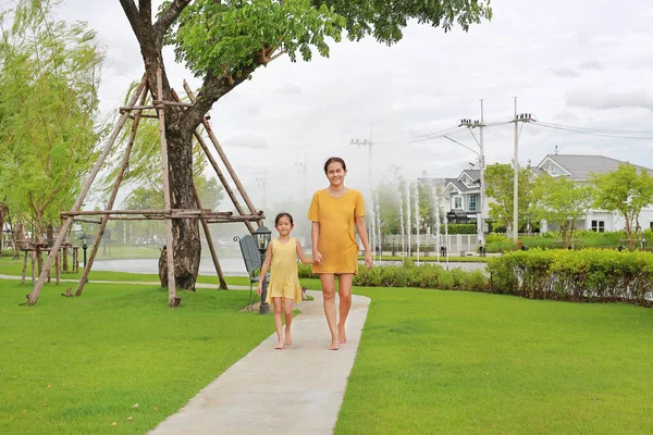 笑顔のアジア系の母親と娘の手の肖像画は 屋外の庭で散歩をリラックス 夏の公園で一緒に過ごすママと子供 — ストック写真