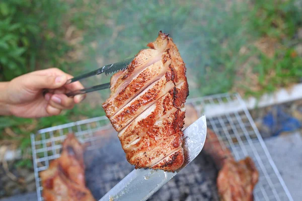 炭火焼ストーブの上にバーベキューの手を保持作品 グリルでおいしい豚肉を焼きます — ストック写真