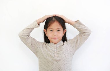 Küçük tatlı Asyalı kız el ele tutuşup beyaz arka planda izole edilmiş kameraya bakıyor..