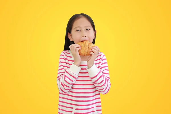 Asiatique Petit Enfant Fille Manger Croissant Isolé Sur Fond Jaune — Photo