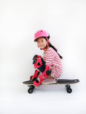 Beyaz arka planda izole edilmiş kaykayla kayan Asyalı bir çocuğun portresi. Kaykay süren bir çocuk.