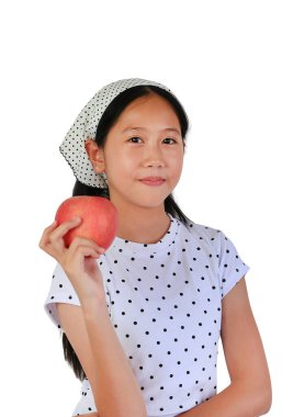 Puantiyeli tişört giyen yakışıklı Asyalı genç bir kız ve bandana elinde taze kırmızı bir elma tutuyor. Beyaz arka planda hafif bir gülümsemeyle sağlıklı beslenmeyi teşvik ediyor..