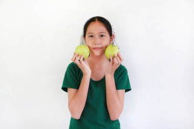 Asyalı genç kızın portresi beyaz arka planda taze bir guava, yeşil bir meyve sergiliyor..