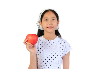 Puantiyeli tişört ve bandana giyen Asyalı kızın portresi taze kırmızı bir elma tutuyor, beyaz arka planda hafif bir gülümsemeyle sağlıklı beslenmeyi teşvik ediyor..