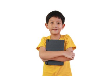 Siyah bir not defterini tutarken gülümseyen ve sarılan sarı tişörtlü yakışıklı Asyalı çocuk beyaz arka planda izole edilmiş..