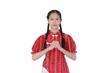 Saçları örgülü, zarif bir Asyalı kız geleneksel bir selamlama sergiliyor. Beyaz arka planda şık kırmızı bir Çin tarzı bluz giyiyor..