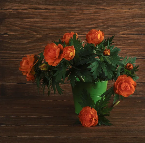 Букет красочных цветов в декоративном ведре на деревянном фоне — стоковое фото