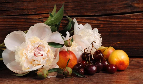Peony, cherry and peach. Still life with fresh berries and flowers. — Stock Photo, Image