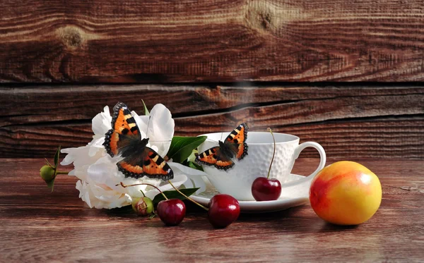 Kaffee, Kirsche, Blume und Schmetterling auf Holzgrund — Stockfoto