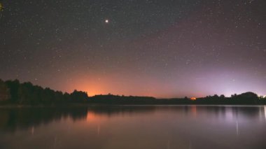 Lyepyel Bölgesi, Vitebsk Eyaleti, Belarus. Lepel Gölü üzerindeki gerçek renkli gece yıldızları. Doğal Yıldızlı Gökyüzü Arkaplan Manzarası. Zaman aşımı. 4K
