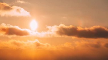 Pofuduk Bulutlu 4K Günbatımı Gökyüzü. Sunset Sky Doğal Arkaplanı. Güneş ışınları, güneş ışınları, dramatik gökyüzü. Sarı, Turuncu, Pembe Renkli Günbatımı Hızlandırılmış Zaman Hızlandırması. Günden Akşama Geçiş