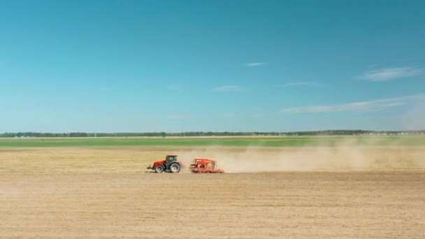4K Aerial View traktor vetőgéppel Vetés a vetőmag a növények a tavaszi szezonban. A mezőgazdasági tavaszi szezon kezdete. Vidéki Vidéki Tájkép. Filmforgatás — Stock videók