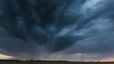 Kırsal Buğday Tarlası üzerinde Yaz Yağmurlu Günbatımı Gecesi. Horizon 'da yağmur bulutları olan dramatik gökyüzü. Tarım ve Hava Durumu