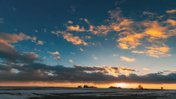 Champ de pré d'hiver au coucher du soleil du soir. Couleurs naturelles du ciel dramatique lumineux au-dessus du paysage enneigé de campagne. Paysage agricole En janvier. Temps écoulé Temps écoulé Temps écoulé — Video