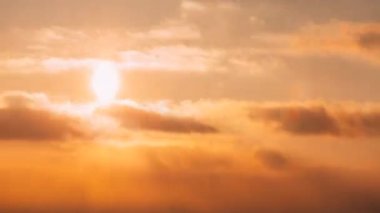 Pofuduk Bulutlu 4K Günbatımı Gökyüzü. Sunset Sky Doğal Arkaplanı. Güneş ışınları, güneş ışınları, dramatik gökyüzü. Sarı, Turuncu, Pembe Renkli Günbatımı Hızlandırılmış Zaman Hızlandırması. Günden Akşama Geçiş