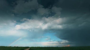 Yağmurlu Bulutlu Dramatik Gökyüzü ve Horizon 'da Yağmurdan Sonra Kırsal Arazi Yolu' nda Gökkuşağı. Tarım ve hava tahmini konsepti. Zaman aşımı, Zaman aşımı, Zaman aşımı 4K Görünümü