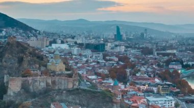 Tiflis, Georgia. Gece Aydınlanmasındaki Ünlü Simgelerin En İyi Manzarası. Gürcistan başkenti Skyline Cityscape. Günbatımında Şehir ve Gece Aydınlanması. Gündüzden Geceye Geçiş