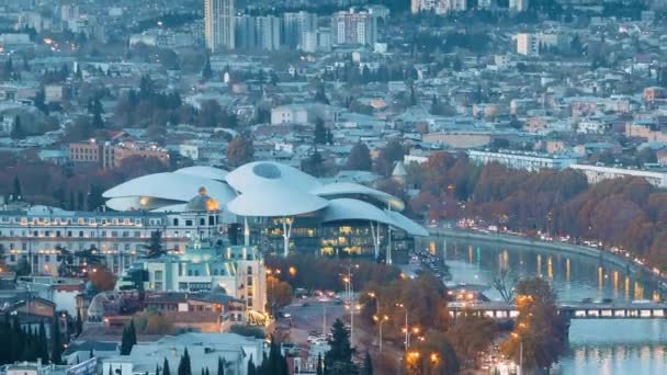 Tbilisi och Georgia. Top View Of Famous Landmarks In Night Illuminations. Georgiens huvudstad Skyline Cityscape. Staden under solnedgång och nattbelysning. Dag till natt övergång — Stockvideo