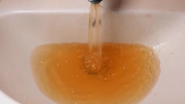 El agua oxidada sale del grifo. Contaminación del agua. Medio ambiente mundial — Vídeo de stock
