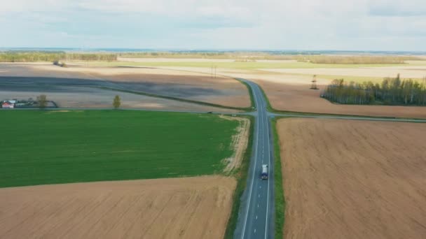 Ciężarówka cysterna, ciężarówka z paliwem, cysterna. Widok z lotu ptaka na autostradę przez pole i letni krajobraz. Widok z góry Ciągnik Jednostka Prime Mover Traction Unit w ruchu na autostradzie. Biznes — Wideo stockowe