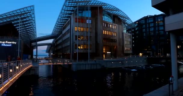 Oslo, Noruega - 24 de junho de 2019: Pessoas caminhando perto do Astrup Fearnley Museum of Modern Art, residencial Casas de vários andares em Aker Brygge District In Summer Evening Night. Lugar famoso e popular. 4K — Vídeo de Stock