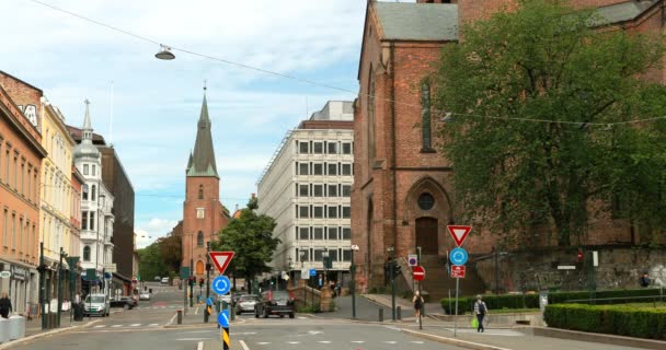 挪威奥斯陆- 2019年6月24日：位于Akersgata街的Trefoldighetskirken-Holy Trinity Church附近的交通。夏日。圣奥拉夫大教堂背景。4K — 图库视频影像