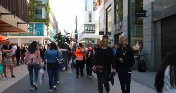 Stockholm, Sweden - June 28, 2019: Tourrists People Walking In Famous Drottninggata Street. Улица Королевы Дринггатан в Стокгольме, Швеция, является главной пешеходной улицей с множеством магазинов. 4K — стоковое видео