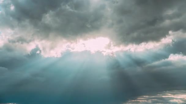 Солнечные лучи светят сквозь темные облака в облачном голубом небе. Естественный фон 4K Time. Природные погодные условия. 4К Облачное Небо с Пушистыми Облаками. Закат Неба — стоковое видео
