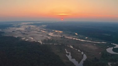 Misty Landscape 'te İnanılmaz Gün Doğumu. Puslu Orman ve Nehir 'in üstünde yükselen güneşle birlikte sisli bir sabah manzarası. Yaz Başları Doğası.