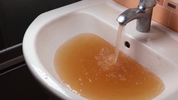 El agua oxidada sale del grifo. Contaminación del agua. Medio ambiente mundial — Vídeo de stock