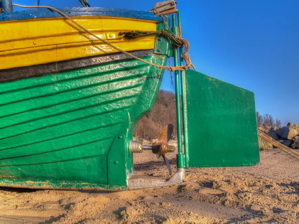 Hélice de aço e leme de um barco de pesca em uma praia de areia — Fotografia de Stock