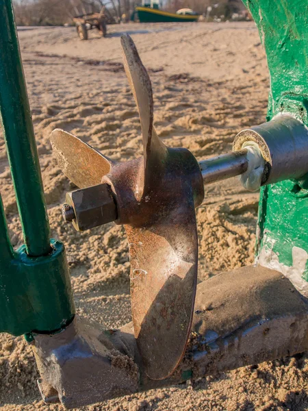 Stahlpropeller und Ruder eines Fischerbootes an einem Sandstrand — Stockfoto